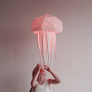 A little girl is holding up a Vasili Lights Nautical Hanging Jelly Light designed for a Child's Room or Nursery.