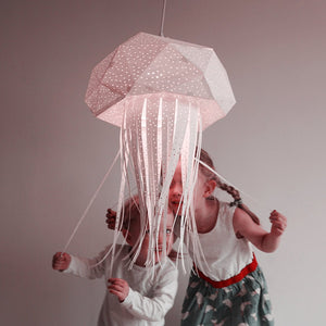 Two children are playing with Nautical Hanging Jellyfish Light designed for a Child's Room or Nursery.