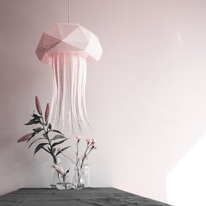Nautical Hanging Jellyfish Light by Vasili Lights hanging above a table next to a vase with flowers.