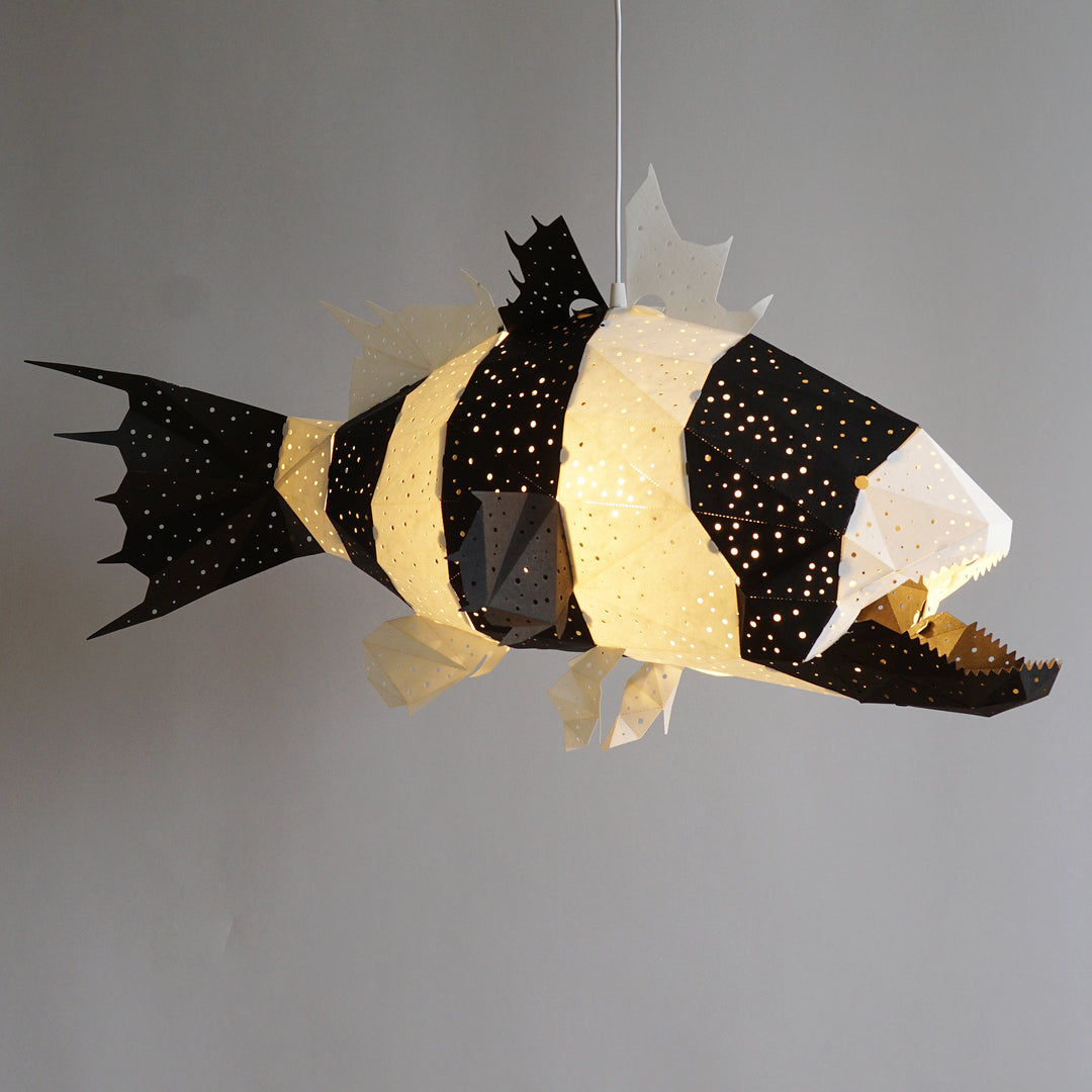 The Black-White Lapu Lapu Origami Fish Pendant Light on a plain grey background