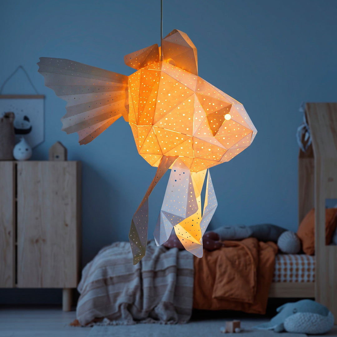 A lit White Baby Goldfish Origami Pendant Light in a blue nursery with toys