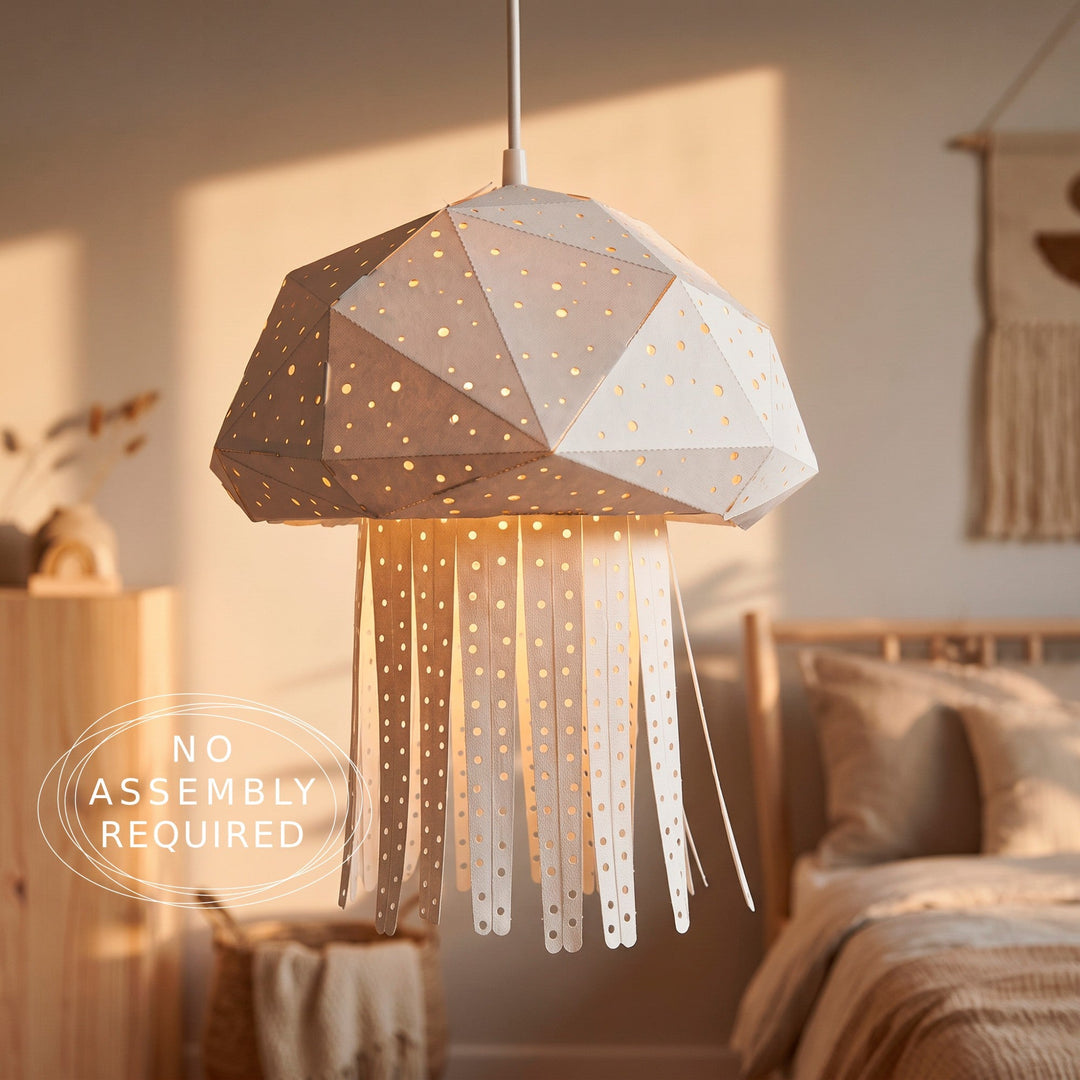 A modern geometric jellyfish pendant light hanging in a warm, sunlit bedroom. The light features a faceted dome shade with gold star cutouts and long, flowing tentacle-like strips below, casting a soft warm glow.
