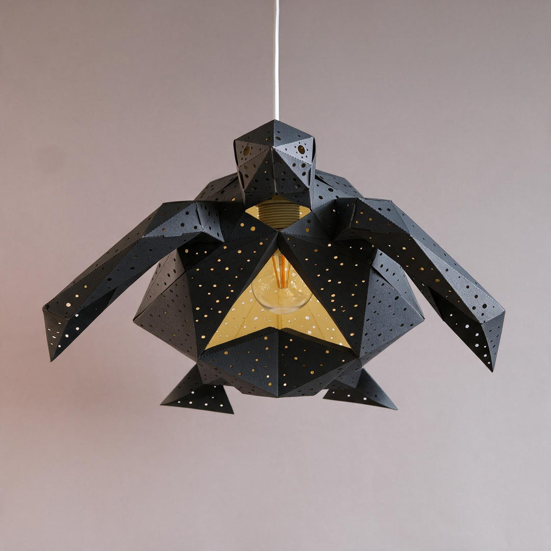 A Black Baby Sea Turtle Pendant Light seen from below with its yellow underside panel