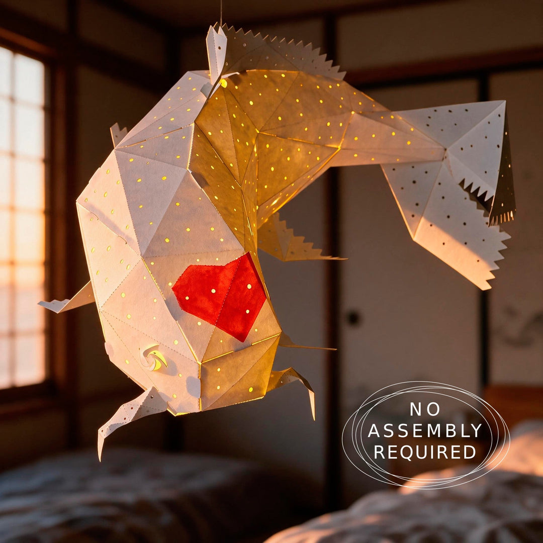 A geometric origami Koi fish hanging lamp with a glowing warm yellow interior and a red heart detail, shown in a Japanese-style room at sunset. 