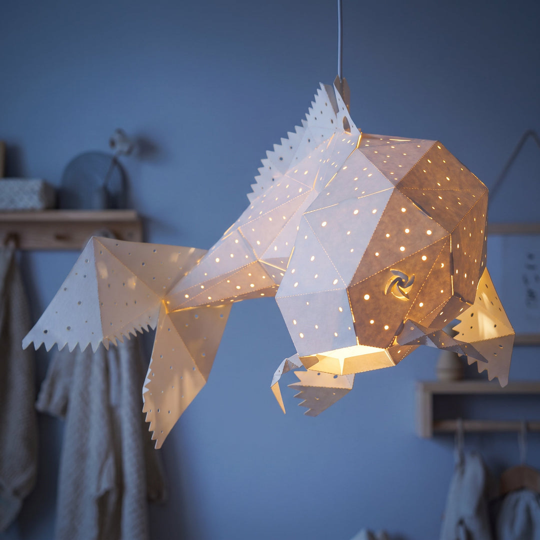 A lit Moonlight Koi Pendant Light in a blue room