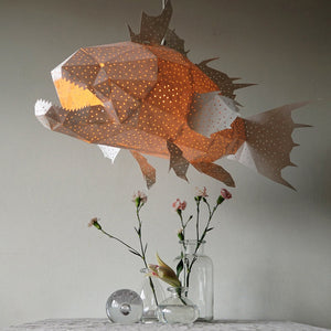 A fish-shaped Nautical Ceiling Lamp hanging above a table next to a vase of flowers, adding a touch of underwater adventure.