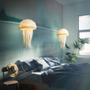 Two Vasili Lights' Nautical Hanging Jellyfish Lights suspended above a bed in a bedroom.